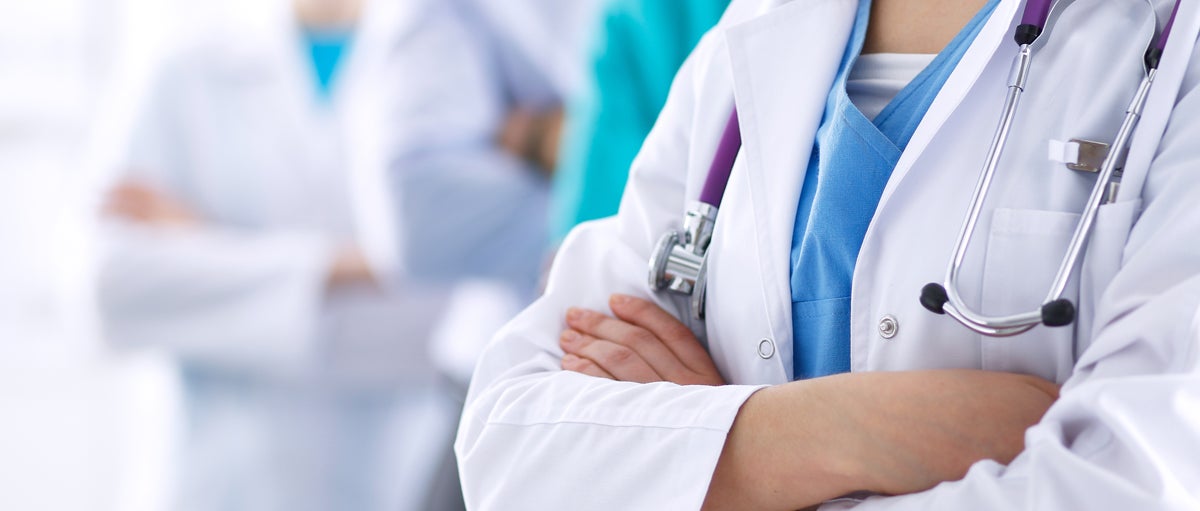 Close-up of doctor with medical professionals in background