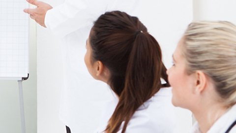 Two medical professionals looking at instructor