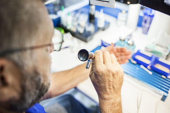 Technician examining surgical instrument