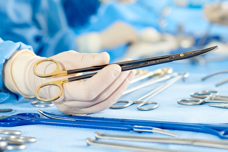Close-up of surgeon holding NOIR™ Dissecting Scissors